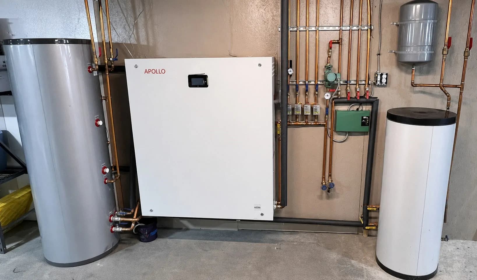 Installed APOLLO Hydro Smart Station with hydronic piping, domestic hot water tank, buffer tank, and expansion tank