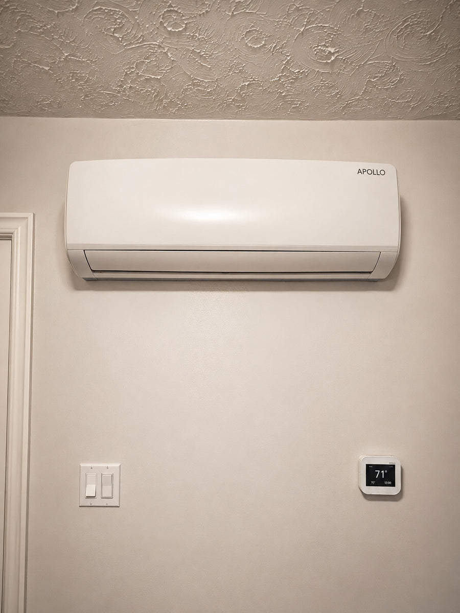 Apollo 1.5 ton wall fan coil installed above a wall-mounted thermostat.