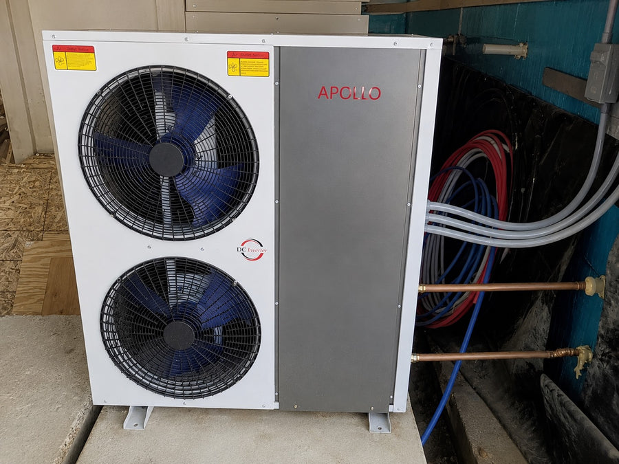 Apollo 5 ton air to water heat pump connected to copper piping and hydronic lines in a utility room.